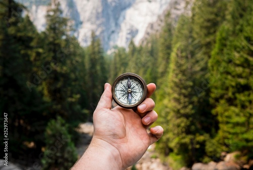 Hand Holding Compass Exploring Mountains
