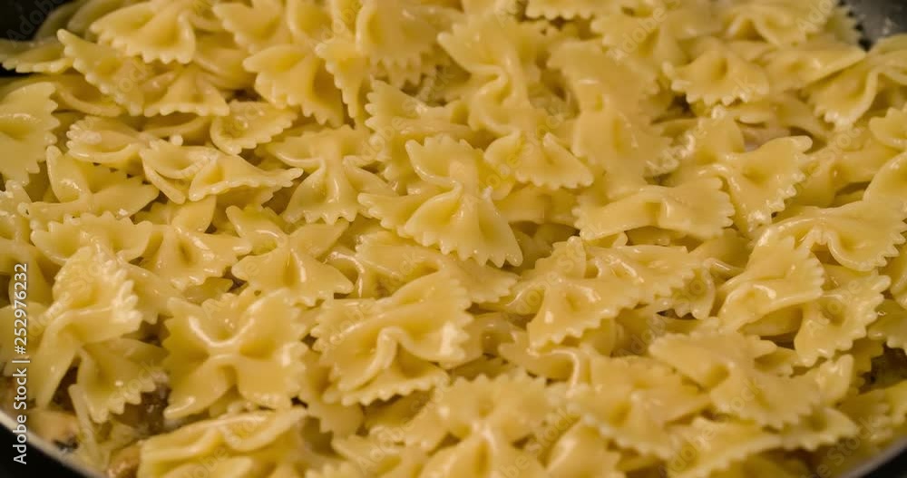 Pouring Pasta in pan with Champignons mushrooms Top view 4K video Pouring Pasta in pan with Champignons mushrooms Top view 4K video