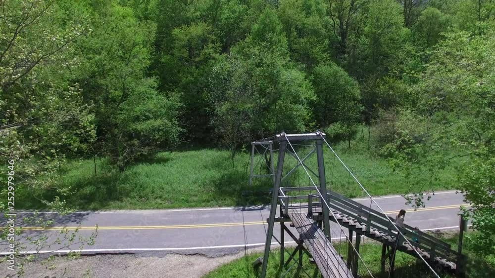 0240_Aerial push alongside Bridge with flag over Creek with girl_DJI_0005m.MOV 0240_Aerial push alongside Bridge with flag over Creek with girl_DJI_0005m.MOV