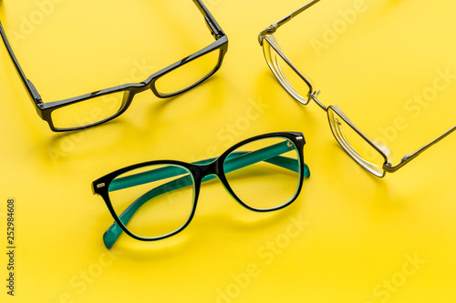 Accessories for eyes. Glasses with transparent lenses and different frames on yellow background