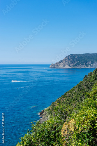 Italy, Cinque Terre, Corniglia, a large body of water with a mountain in the background © SkandaRamana