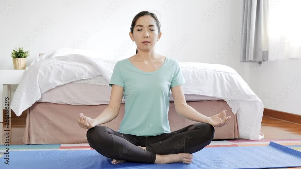 Young beautiful asian woman practice yoga at home. Relaxing home concept.