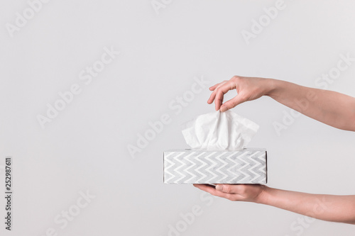 Delicate female hands holding a tissue box