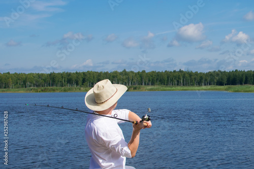 landscape of water, sky and horizon, a man throws a fishing rod to catch a fish