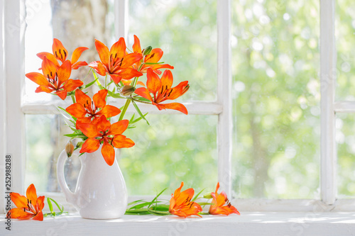 orange lily on windowsill