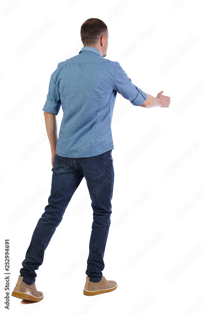 Back view of a walking businessman who stretches his hand for a handshake. Back view of a walking businessman who stretches his hand for a handshake.