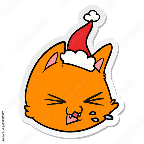 spitting sticker cartoon of a cat face wearing santa hat