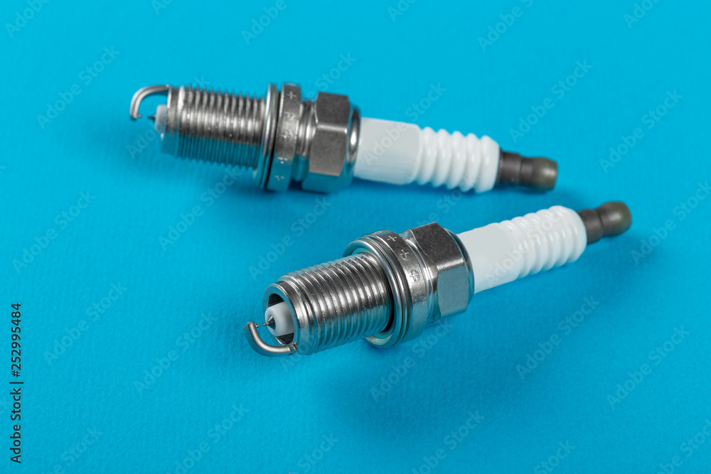 A set of new spark plugs a blue background. A set of new spark plugs a blue background.