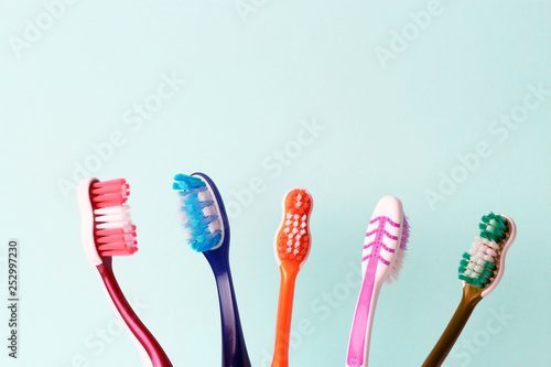 Multicolored toothbrushes on a blue background, copy space