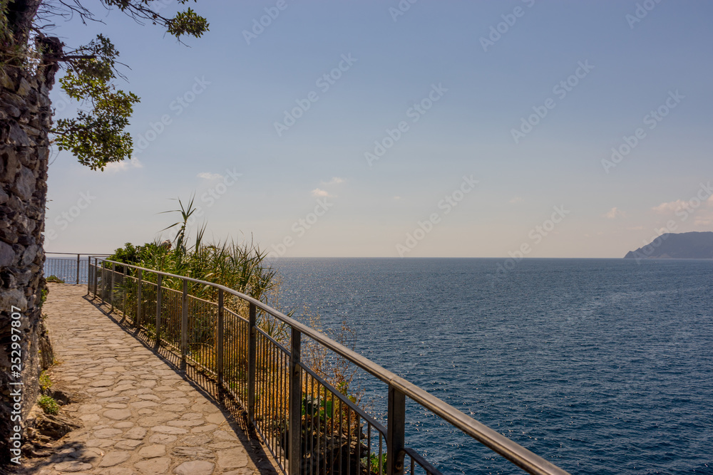 Italy, Cinque Terre, Manarola, a long bridge over a body of water Italy, Cinque Terre, Manarola, a long bridge over a body of water