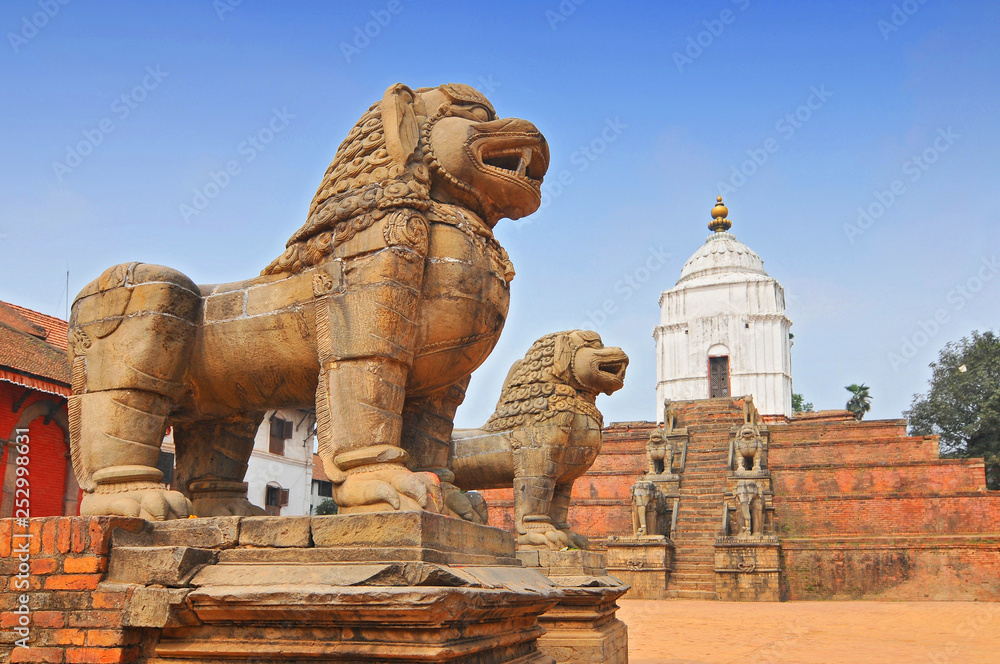 Stone Lions east of Durbar Square with Fasidega Temple in Bhaktapur, Nepal.