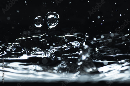Water droplet splash backgound texture isolated on black. Fresh clean pure water ripples and splashes.  