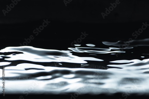 Water droplet splash backgound texture isolated on black. Fresh clean pure water ripples and splashes. 