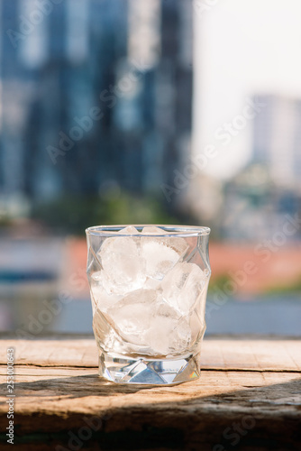 Glasses with ice cubes on wooden table