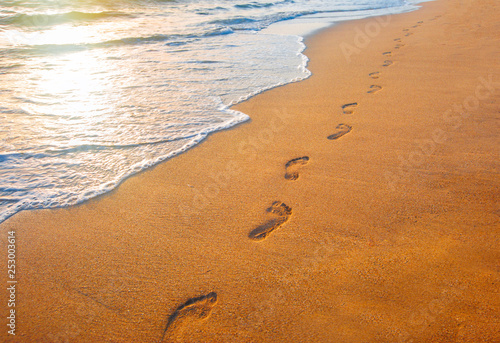 Fototapeta Naklejka Na Ścianę i Meble -  beach, wave and footprints at sunset time