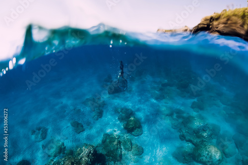 Freediver in wetsuit dive underwater in the ocean