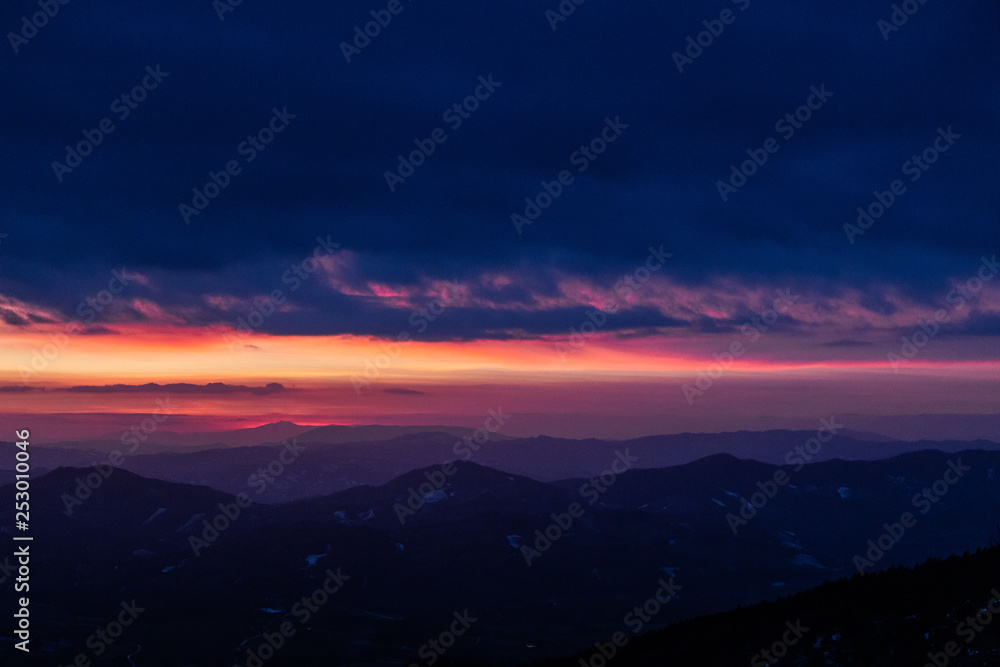 Beautifully colored sky at dusk, with mountains layers