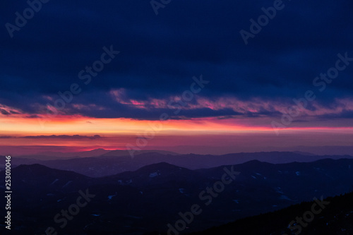 Beautifully colored sky at dusk, with mountains layers