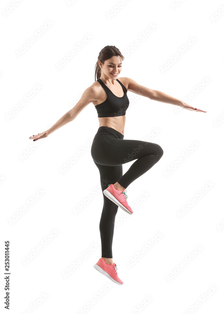Sporty young woman jumping against white background