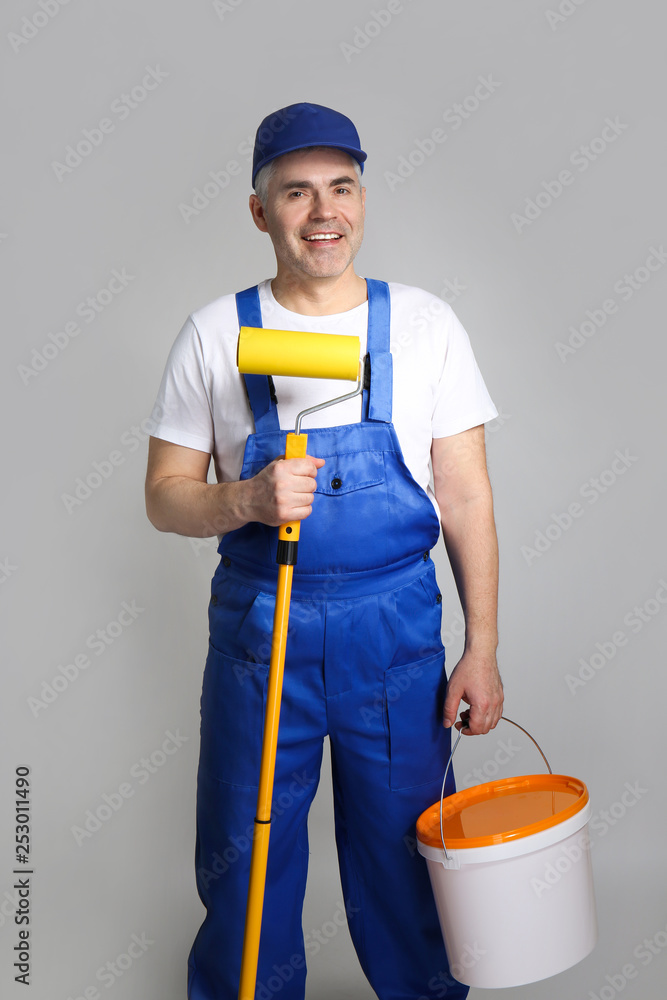 Mature male decorator on grey background Mature male decorator on grey background