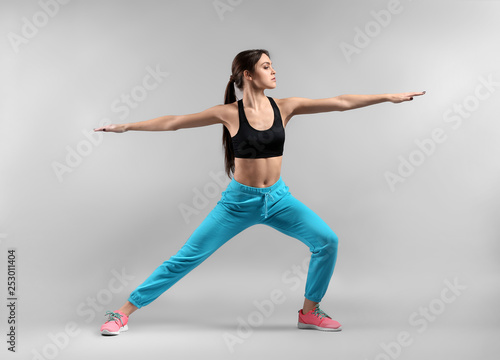 Sporty young woman on light background