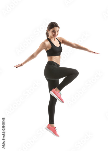 Sporty young woman jumping against white background © Pixel-Shot