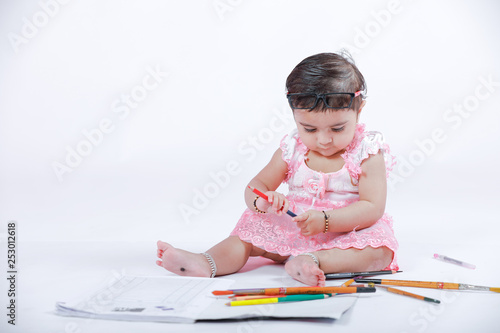Cute little Indian/Asian Girl enjoying Painting with paper, colour pencle and art brush