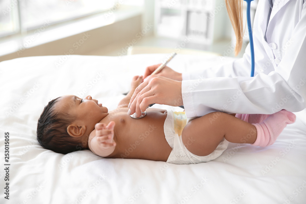 Pediatrician examining African-American baby in clinic Pediatrician examining African-American baby in clinic