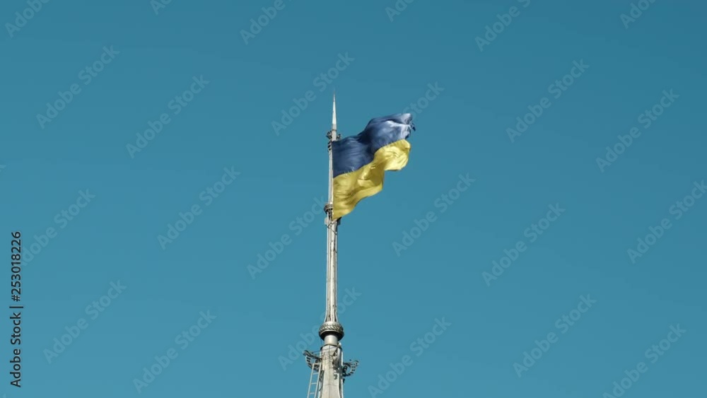 Ukrainian flag against the blue sky in the wind.