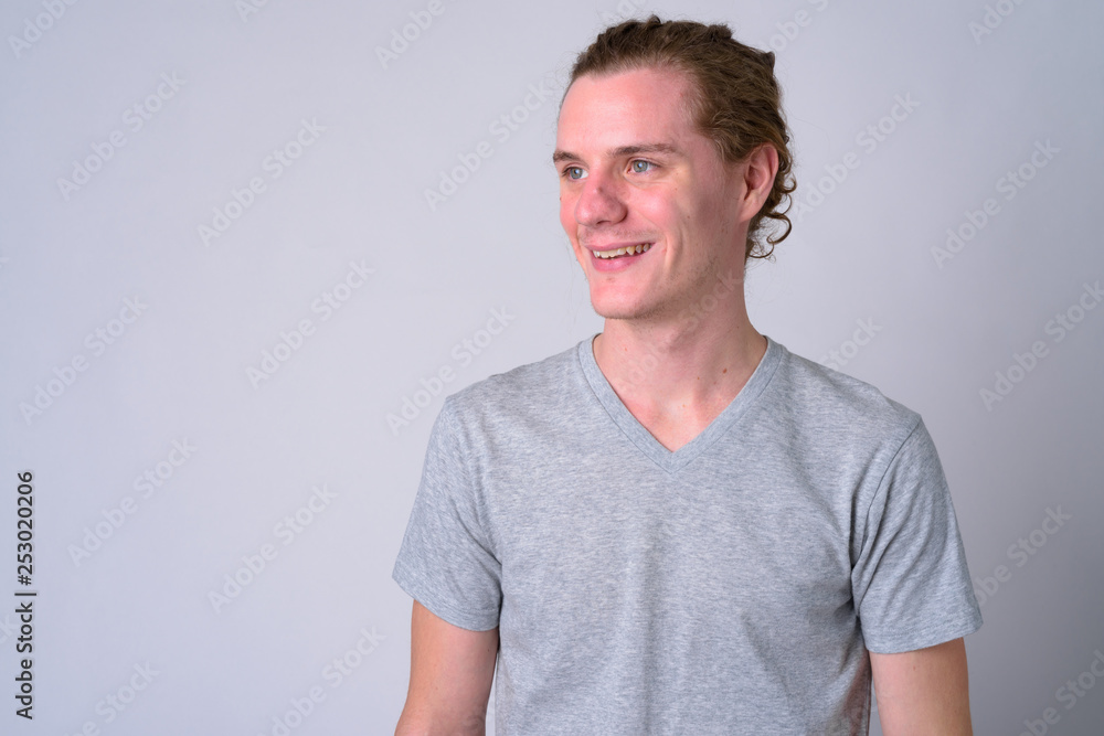 Obraz premium Portrait of happy young handsome man smiling and thinking