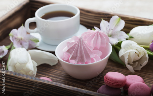 Tulips and cup of coffee with dessert on white background. Conce