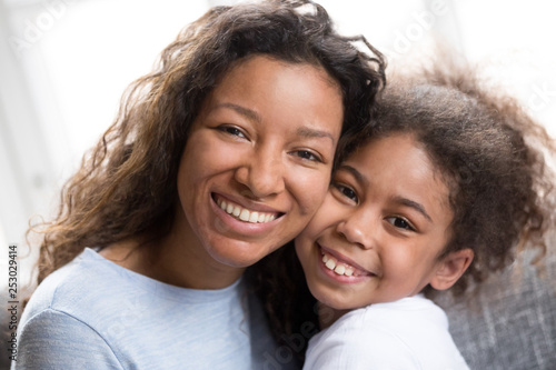 Cuadro en lienzo Portrait of mixed race mom and daughter hug at home