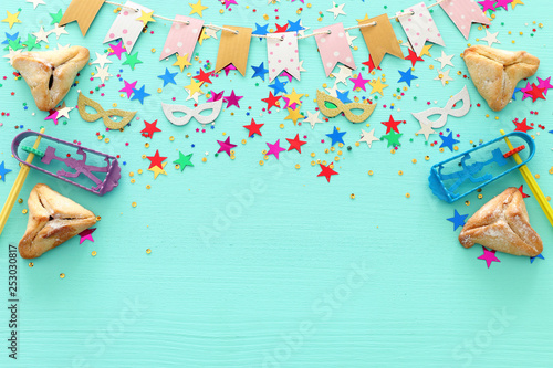 Purim celebration concept (jewish carnival holiday) over wooden pastel blue background. top view, flat lay