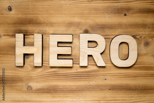 HERO word made of wooden block letters on wooden board.
