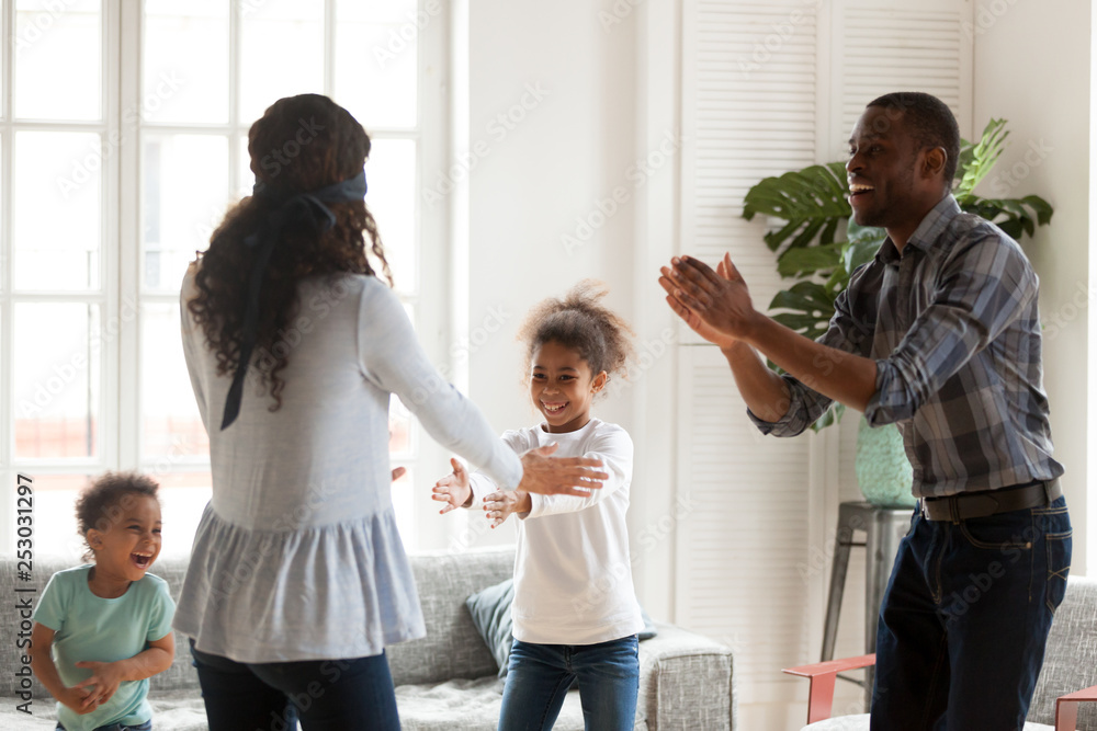 © fizkes - Happy black family play hide and seek at home together © fizkes - Happy black family play hide and seek at home together