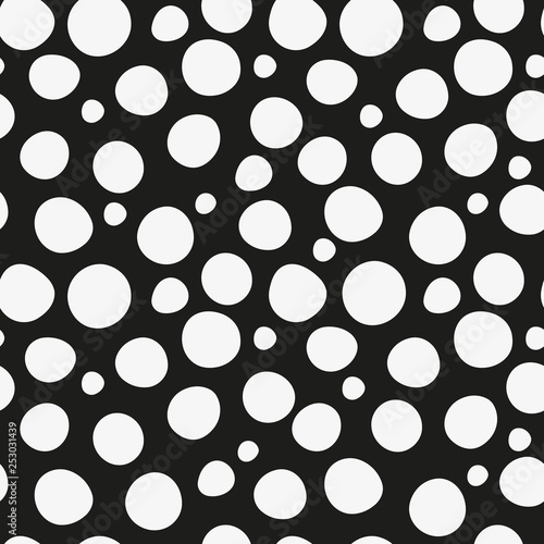 Seamless two-tone pattern with white large and small deformed polka dots
