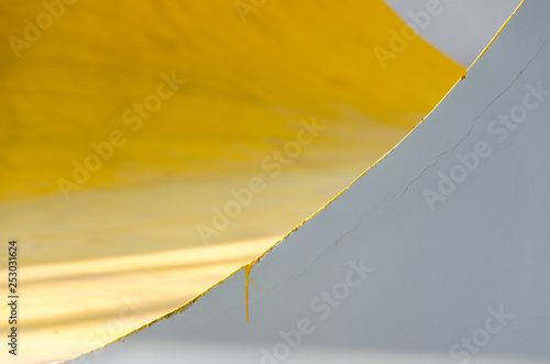 Colorful (yellow, gray, white) painted wall with cracks. Abstract colorful background with texture, mix yellow and grey, covers with minimal design. Shallow depth of focus.