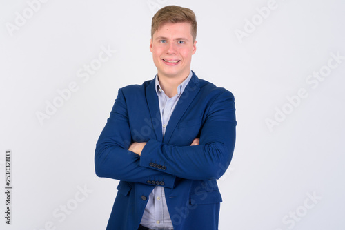 Portrait of young happy blonde businessman smiling with arms crossed