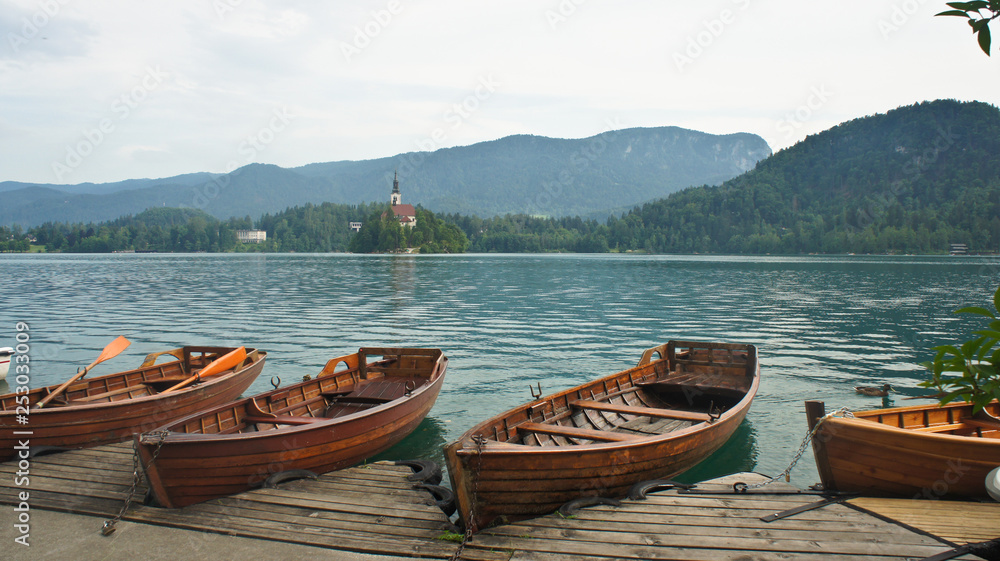 Beautiful view over Lake Bled, Julian Alps, boats and church on the island, sunny day, Bled, Slovenia