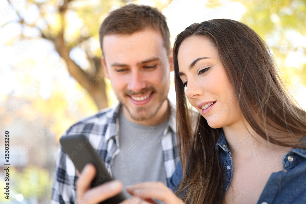 Couple using smart phone checking online content Couple using smart phone checking online content
