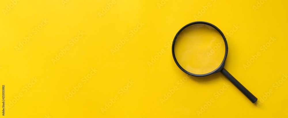 close up magnifier glass on yellow background 