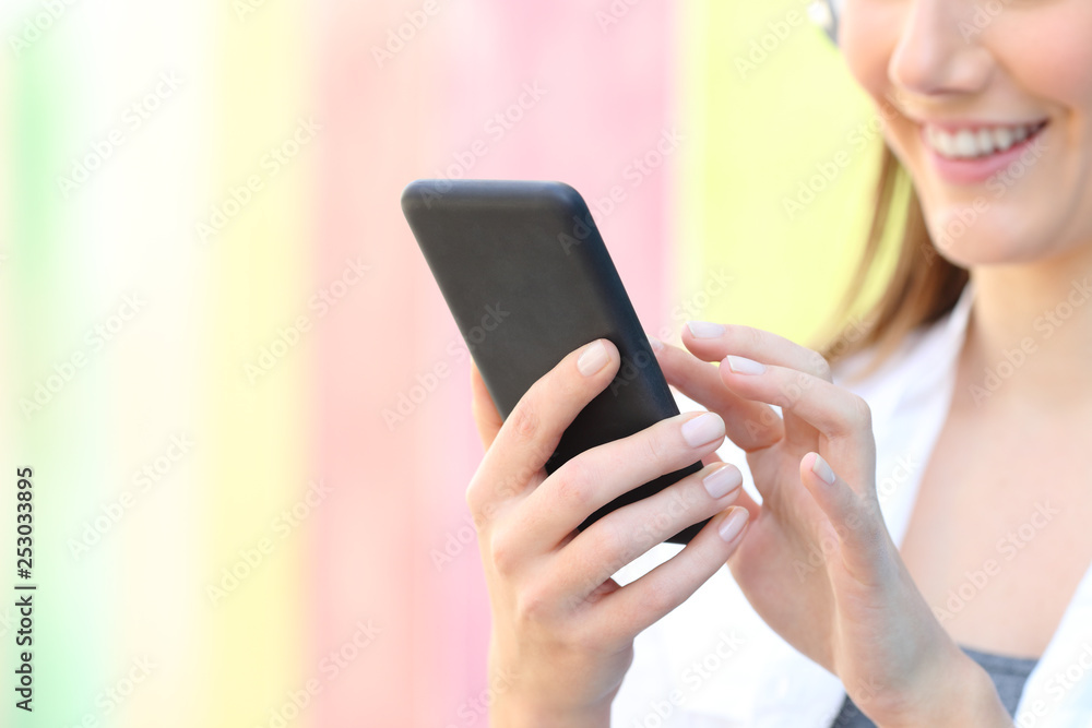 Close up of a woman hand using smart phone on colorful background