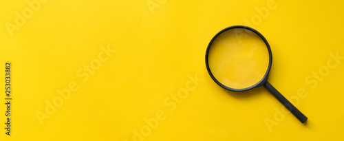 close up magnifier glass on yellow background  photo