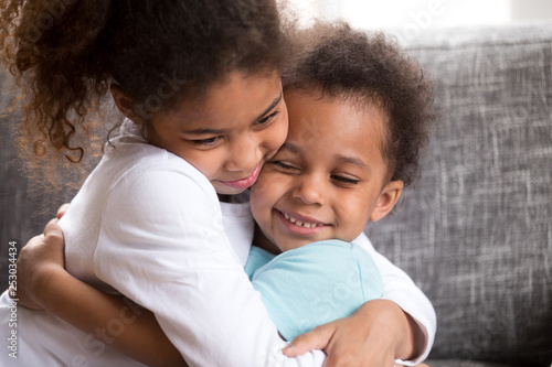 Cute mixed race kids hug making peace at home