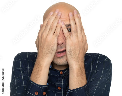 afraid man covering his face with hands
