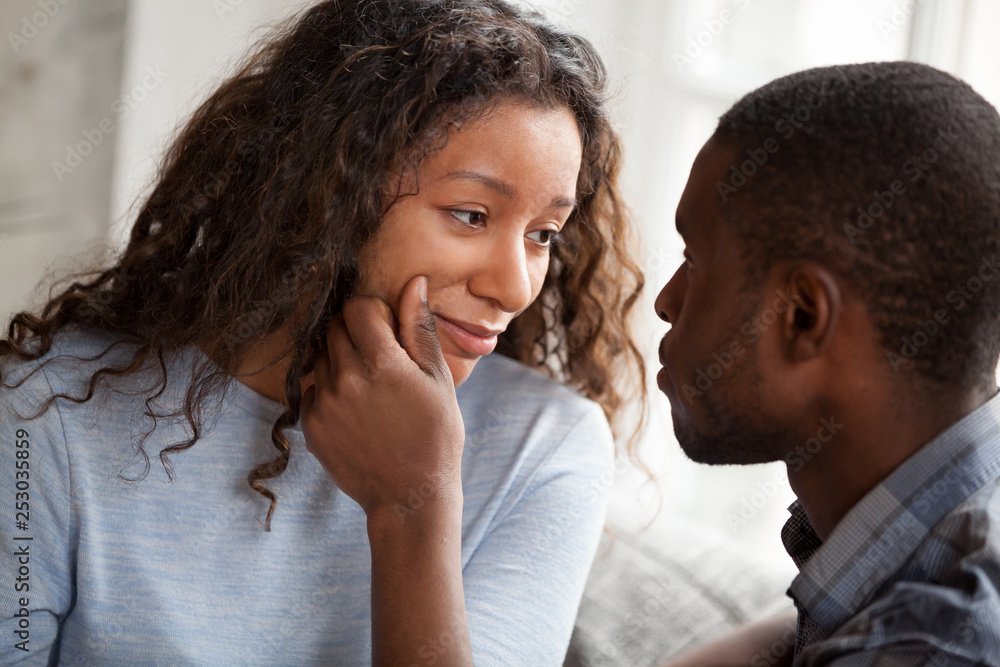 Obraz premium Loving black man cheering sad young girlfriend