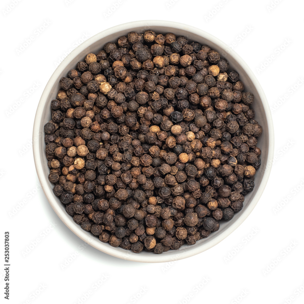 Black dried pepper in bowl isolated on white background. Top view Black dried pepper in bowl isolated on white background. Top view