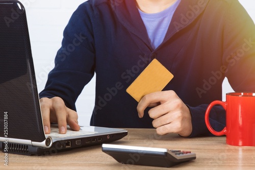 hand closeup with credit card and laptop, shopping online