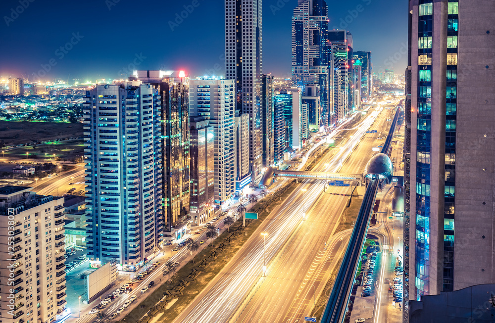 Obraz premium Aerial view on downtown Dubai, UAE with highways and skyscrapers. Scenic nighttime skyline.