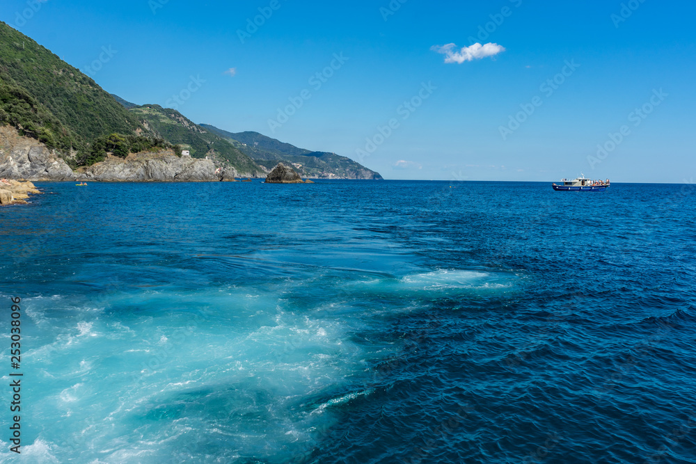 Italy, Cinque Terre, Monterosso, a body of water with a mountain in the ocean
